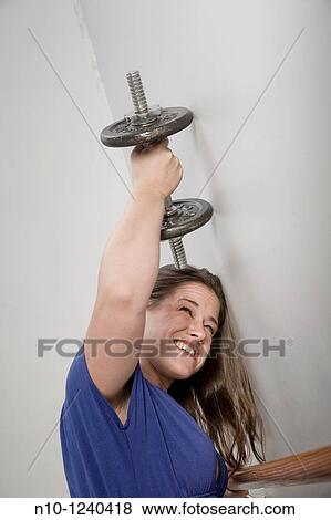 Young woman lifting weights View Large Photo Image Stock Photo - Young woman lifting weights. Fotosearch
