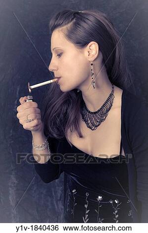 Young woman lighting a cigarette View Large Photo Image Stock Photograph - Young woman lighting a cigarette. Fotosearch