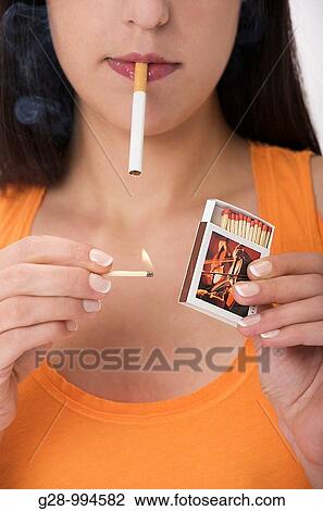 young woman lighting a cigarette with a match View Large Photo Image Stock Image - young woman lighting a cigarette with a match. Fotosearch
