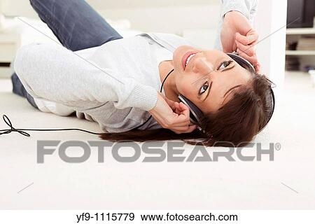 Young woman listening music lying on floor. View Large Photo Image Stock Photo - Young woman listening music lying on floor.. Fotosearch
