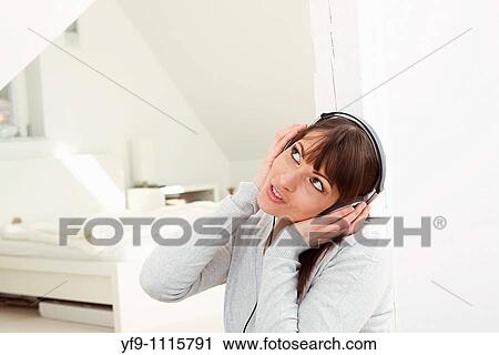 Stock Image - Young woman listening music.. Fotosearch