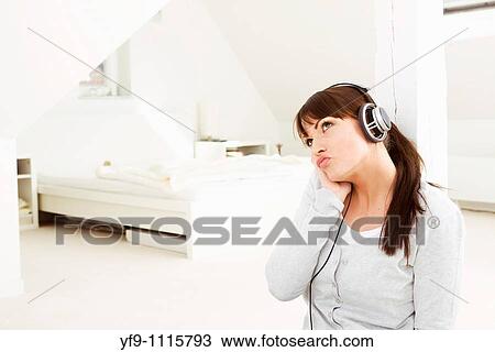 Stock Image - Young woman listening music.. Fotosearch
