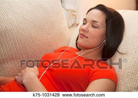 young woman listening to music on mp3 player View Large Photo Image Stock Photo - young woman listening to music on mp3 player. Fotosearch