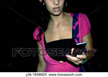 Young woman looking at cell phone View Large Photo Image Picture - Young woman looking at cell phone. Fotosearch