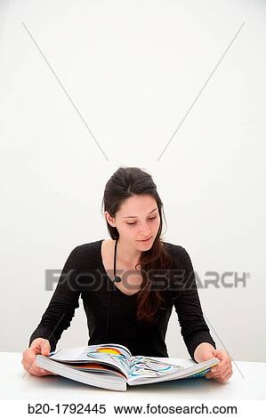 Stock Photography - Young woman looking at exhibition catalog. David Hockney,? A Bigger Picture? exhibition, Guggenheim Museum, Bilbao, Biscay, Basque Country, Spain. Fotosearch