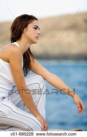 Stock Photo - Young woman looking at the sea. Fotosearch