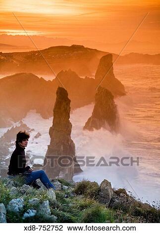 young woman looking from a rocky coast Liencres, Cantabria, Spain, Europe View Large Photo Image Stock Image - young woman looking from a rocky coast Liencres, Cantabria, Spain, Europe. Fotosearch