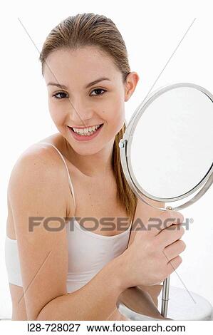 Young woman looking in mirror, View Large Photo Image Stock Photo - Young woman looking in mirror,. Fotosearch
