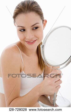 Young woman looking in mirror, View Large Photo Image Stock Photo - Young woman looking in mirror,. Fotosearch