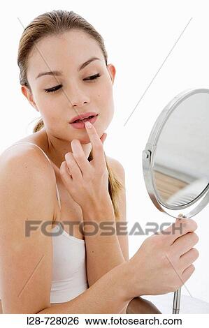Young woman looking in mirror, View Large Photo Image Stock Photograph - Young woman looking in mirror,. Fotosearch