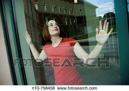 Young woman looking out a window. View Large Photo Image Stock Photo - Young woman looking out a window.. Fotosearch