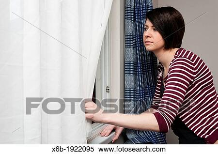 Young woman looking out of window View Large Photo Image Stock Photography - Young woman looking out of window. Fotosearch