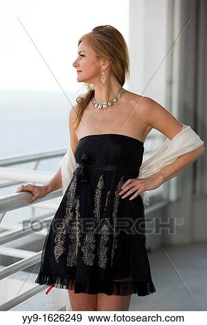 Young woman looking out over balcony railing - South Florida, USA View Large Photo Image Stock Photo - Young woman looking out over balcony railing - South Florida, USA. Fotosearch
