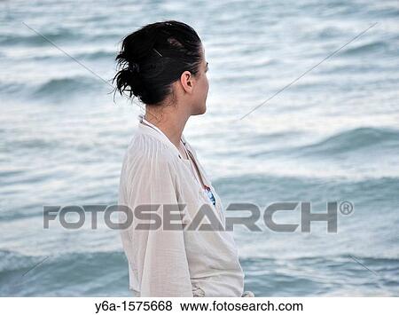 Young woman looking out to sea View Large Photo Image Stock Photo - Young woman looking out to sea. Fotosearch