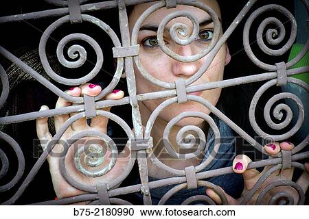 Young woman looking through a fence of a window in the Medina of Fez, Morocco, Africa. View Large Photo Image Stock Image - Young woman looking through a fence of a window in the Medina of Fez, Morocco, Africa.. Fotosearch