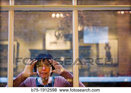 young woman looking through a window inside in Soho, London, England, UK View Large Photo Image Stock Photo - young woman looking through a window inside in Soho, London, England, UK. Fotosearch