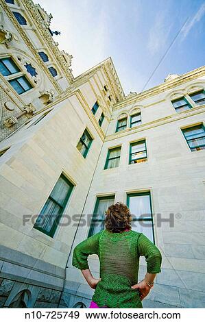 Young woman looking up at a building. View Large Photo Image Stock Photo - Young woman looking up at a building.. Fotosearch