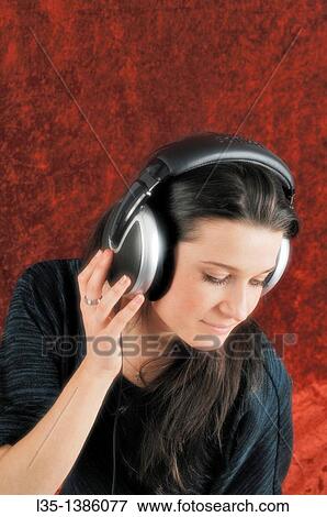 Young woman looks dreamy with headphones View Large Photo Image Stock Photo - Young woman looks dreamy with headphones. Fotosearch