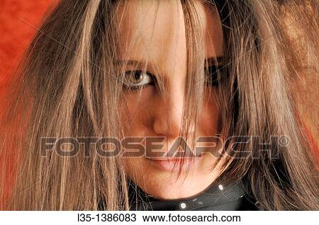Young woman looks into the camera with tousled hairstyle View Large Photo Image Stock Image - Young woman looks into the camera with tousled hairstyle. Fotosearch