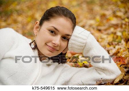 Stock Photography - young woman lying down in leaves. Fotosearch