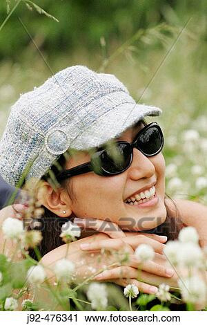 Young woman lying down on the grass View Large Photo Image Stock Image - Young woman lying down on the grass. Fotosearch