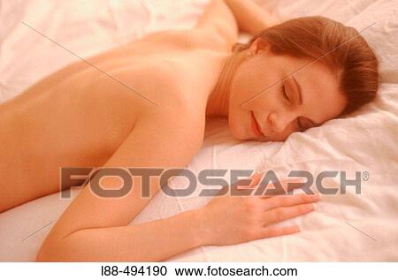 Stock Image - Young woman lying in bed.. Fotosearch
