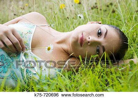 Young woman lying in field of wildflowers View Large Photo Image Stock Photograph - Young woman lying in field of wildflowers. Fotosearch