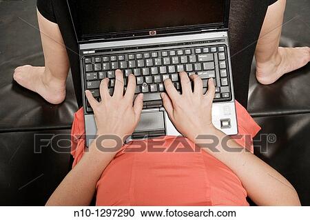 Young woman lying on a mat, working on her laptop computer View Large Photo Image Stock Image - Young woman lying on a mat, working on her laptop computer. Fotosearch