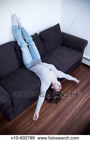 Young woman lying on a sofa. View Large Photo Image Stock Photo - Young woman lying on a sofa.. Fotosearch