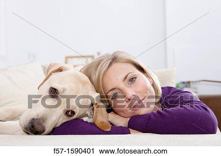 Young woman lying on a sofa with her Dog View Large Photo Image Stock Image - Young woman lying on a sofa with her Dog. Fotosearch