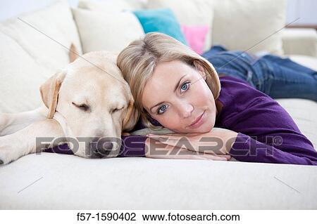 Young woman lying on a sofa with her Dog View Large Photo Image Stock Image - Young woman lying on a sofa with her Dog. Fotosearch