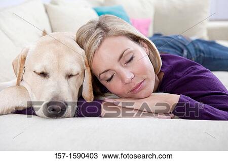 Young woman lying on a sofa with her Dog View Large Photo Image Stock Image - Young woman lying on a sofa with her Dog. Fotosearch
