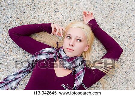 Young woman lying on concrete with hands spread View Large Photo Image Stock Photography - Young woman lying on concrete with hands spread. Fotosearch