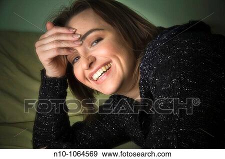 Stock Photo - Young woman lying on her bed. Fotosearch
