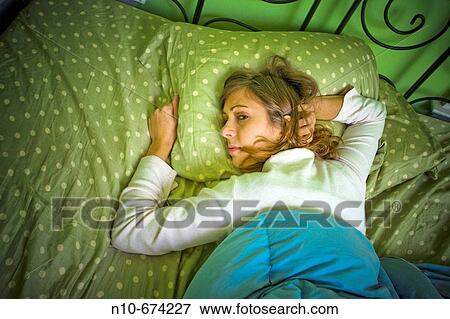 Young woman lying on her bed. View Large Photo Image Stock Photo - Young woman lying on her bed.. Fotosearch
