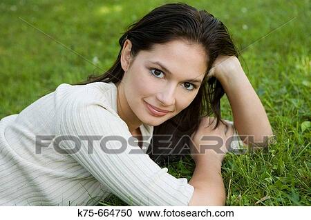 Young woman lying on lawn View Large Photo Image Stock Image - Young woman lying on lawn. Fotosearch