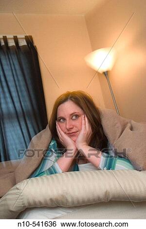 Young woman lying on the bed in her bedroom. View Large Photo Image Stock Photograph - Young woman lying on the bed in her bedroom.. Fotosearch