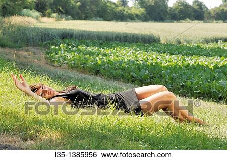 young woman lying on the grass and relax, summer, Germany View Large Photo Image Stock Photograph - young woman lying on the grass and relax, summer, Germany. Fotosearch