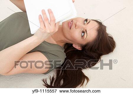 Stock Photo - Young woman lying writing.. Fotosearch