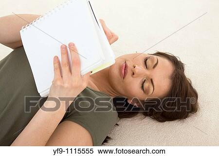 Stock Photography - Young woman lying writing.. Fotosearch