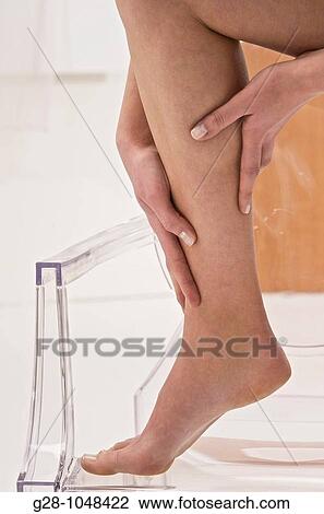 young woman massaging her painful leg View Large Photo Image Stock Image - young woman massaging her painful leg. Fotosearch