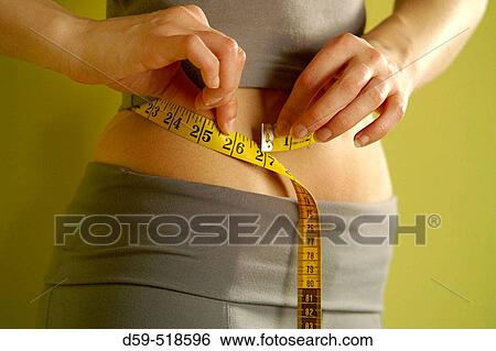 Young woman measuring waistline with tape View Large Photo Image Stock Photograph - Young woman measuring waistline with tape. Fotosearch