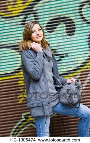 Picture - Young woman next to a colorful wall. Fotosearch
