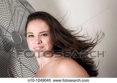 Young woman next to a fan View Large Photo Image Stock Photography - Young woman next to a fan. Fotosearch