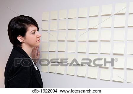 Young woman next to wall of sticky paper notes View Large Photo Image Picture - Young woman next to wall of sticky paper notes. Fotosearch