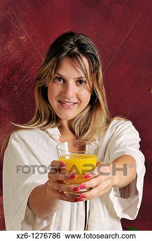 Stock Photograph - Young woman offering orange juice. Fotosearch