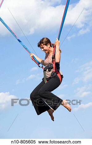 Young woman on a bungee cord ride at a fair. View Large Photo Image Stock Photography - Young woman on a bungee cord ride at a fair.. Fotosearch