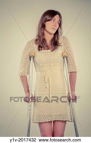 Young woman on a pair of crutches. View Large Photo Image Stock Image - Young woman on a pair of crutches.. Fotosearch