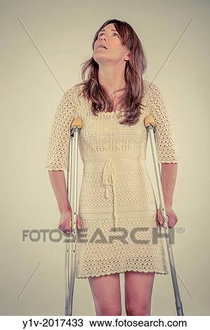 Young woman on a pair of crutches. View Large Photo Image Stock Image - Young woman on a pair of crutches.. Fotosearch