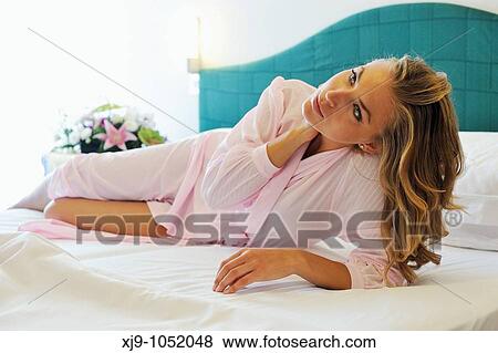 Young woman on bed in hotel room View Large Photo Image Stock Photo - Young woman on bed in hotel room. Fotosearch